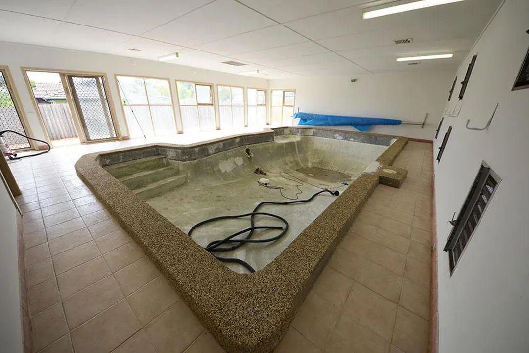 Empty old indoor swimming pool before resurfacing